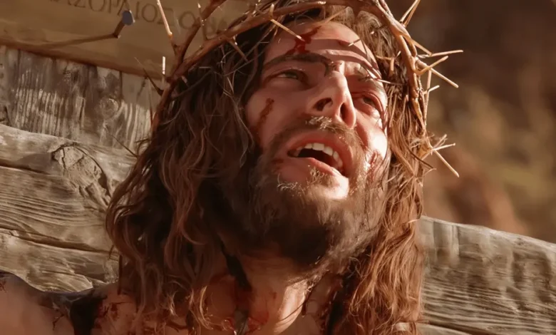 Close-up of Jesus Christ wearing a crown of thorns during crucifixion, a scene from the Gospel of John film.